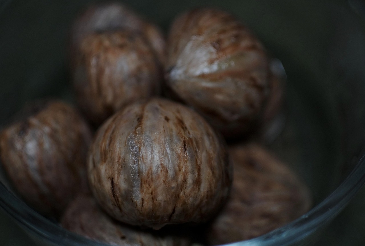 Castagne al forno con incisioni visibili, pronte per la cottura in un tegame.